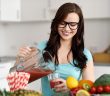 Young woman wearing glasses pouring vegetable