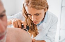 Dermatologist examines skin of patient