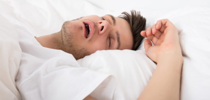 Young Man Snoring While Deep Sleeping In Bed