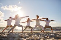 Group of People Doing Yoga By the Beach
