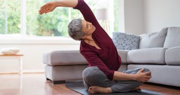 Senior woman sitting and doing yoga exercise